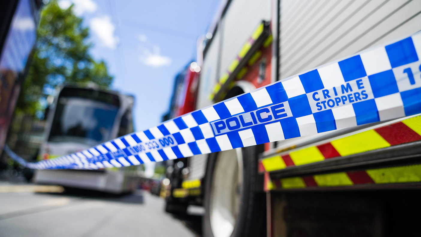 A fire truck and police car behind police tape