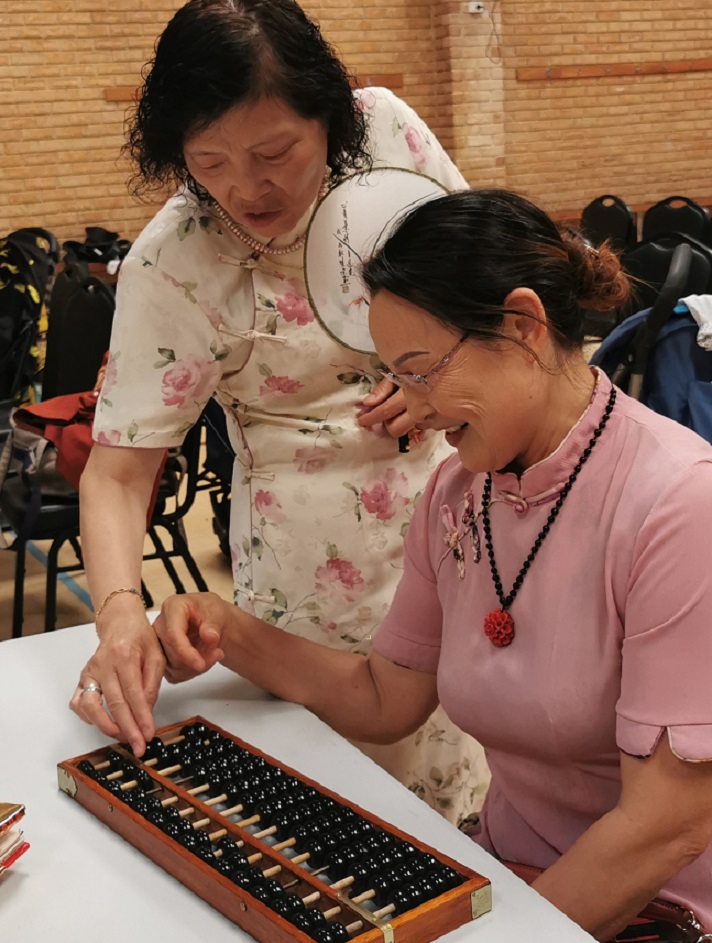 Two women from the Chinese Mothers' Group experiment with a Chinese abacus