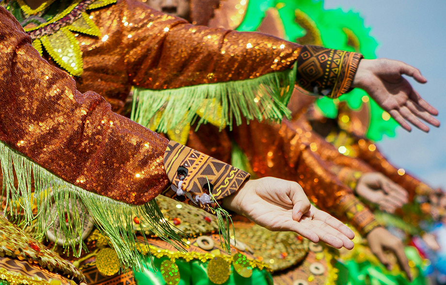 dancers in cultural costume dancing and making hand gesture