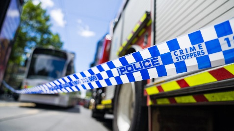 A fire truck and police car behind police tape