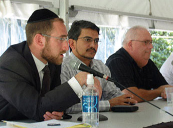 man wearing a kippah speaks into a microphone