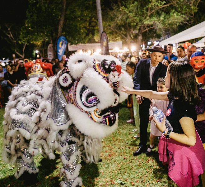 A young girl watching a dragon puppet